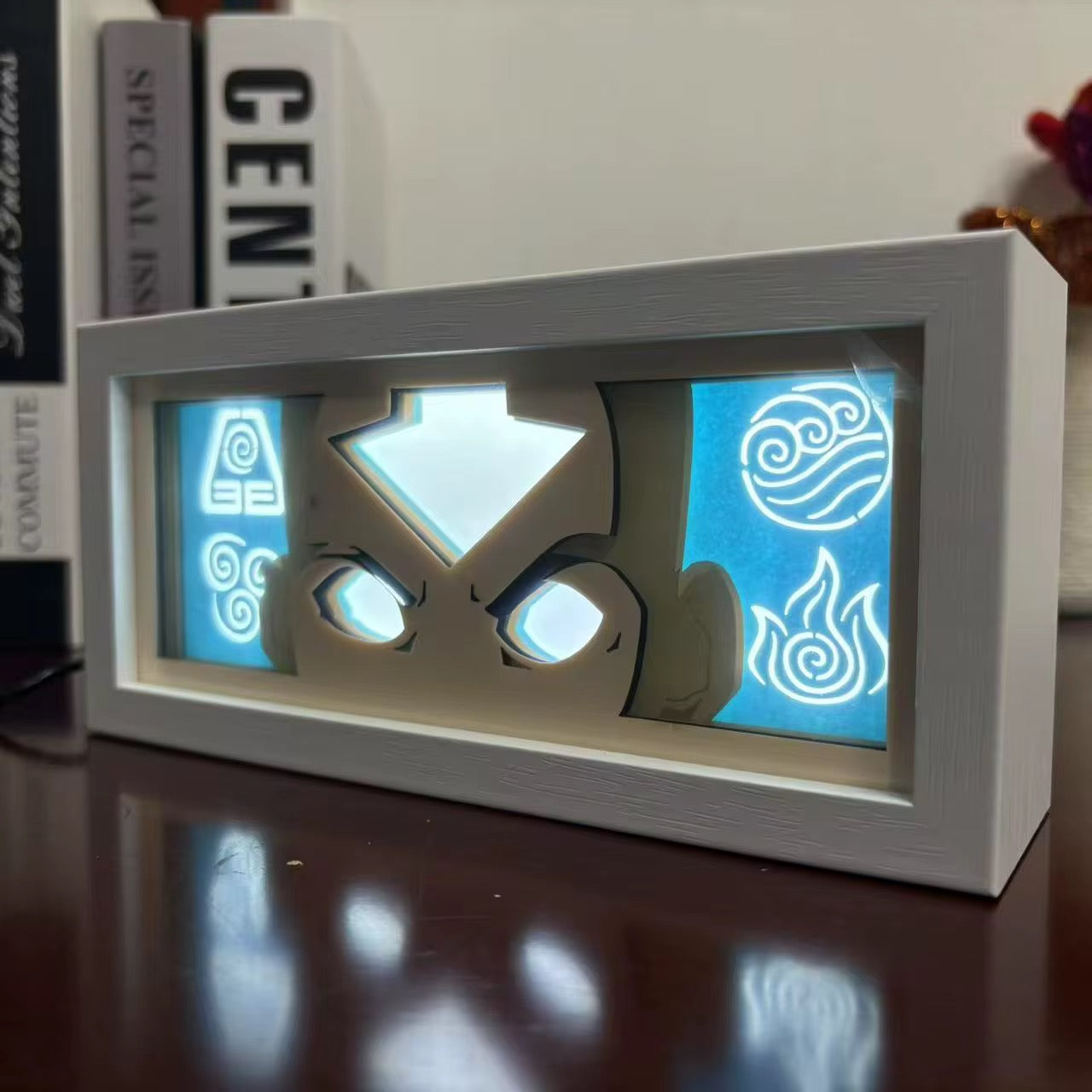 Gros plan des Aang Avatar State Box sur une table en bois avec des symboles illuminés