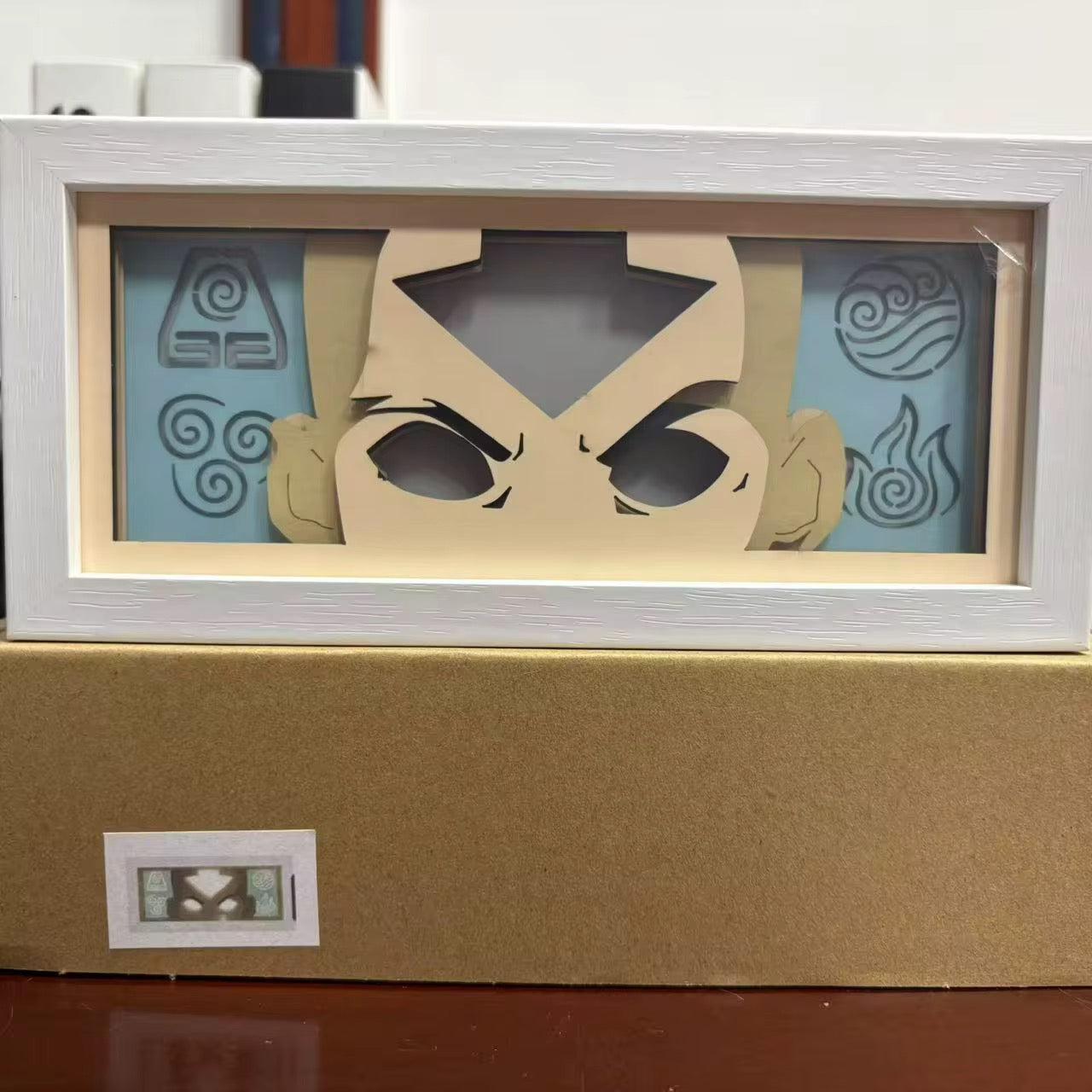 Angle de haut en bas de la boîte lumineuse à l'état Aang Avatar illuminé sur une base brune