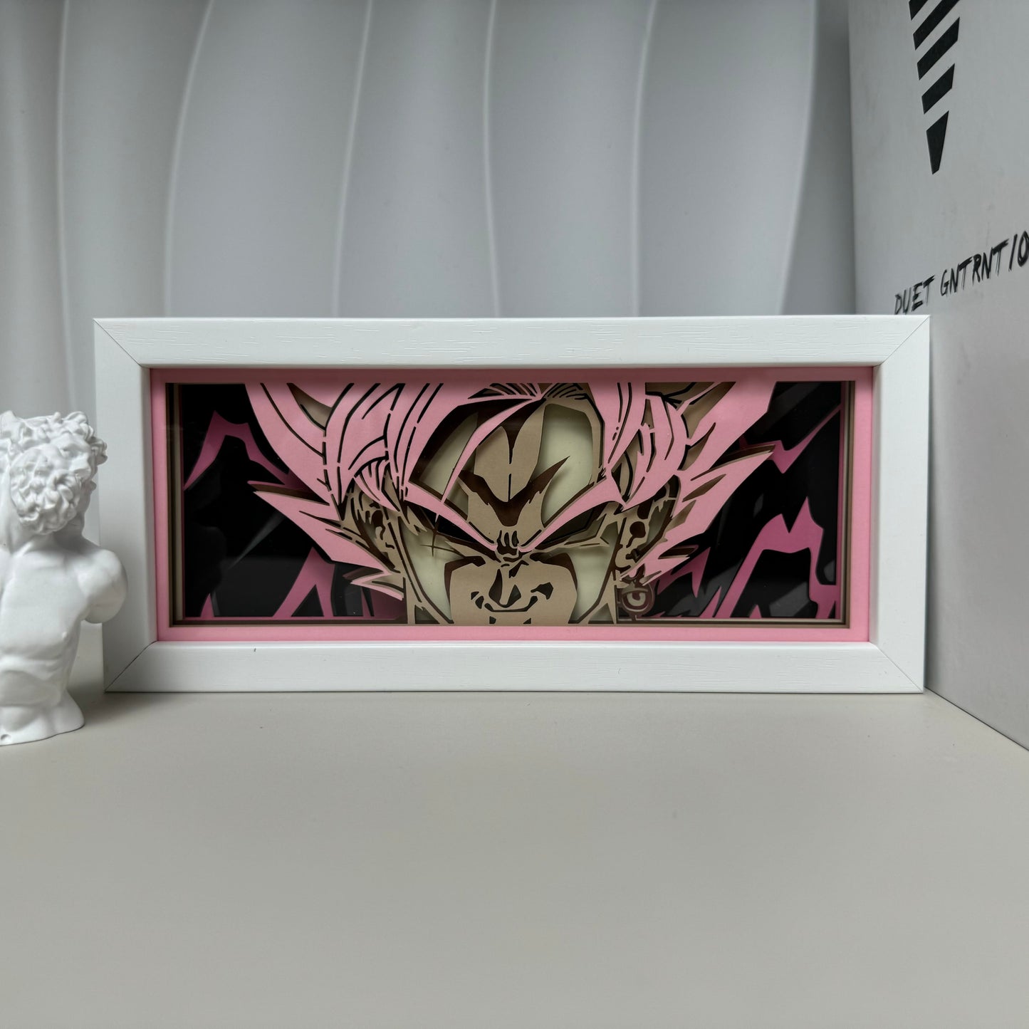 Goku God Mode Anime Light Box od MyanimelightBox, displej, v bílém rámu s ozdobným pozadím