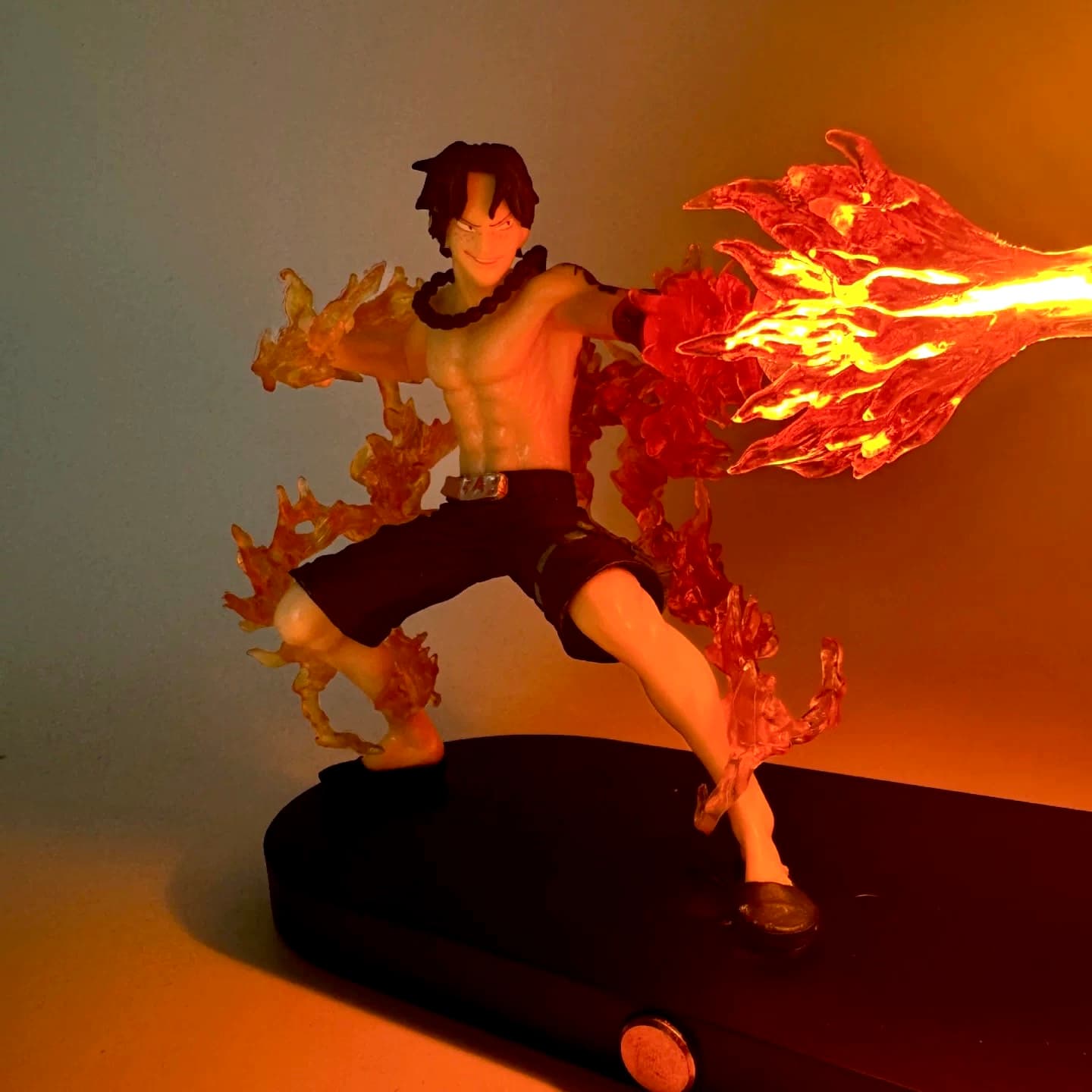 Close-up of Ace figure unleashing illuminated fire effects with glowing LED flame.
