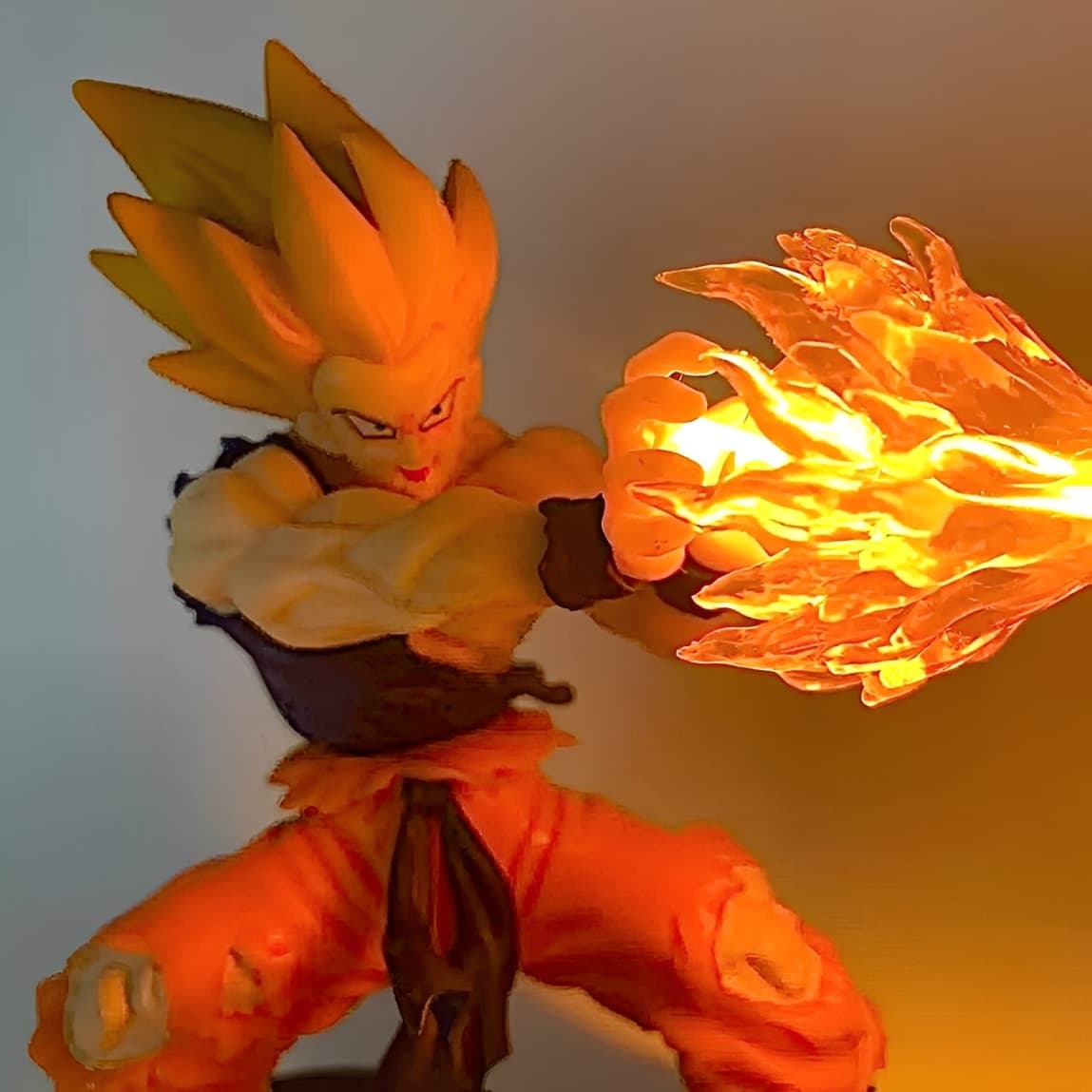 Close-up of Super Saiyan Goku launching a bright LED fire attack effect.

