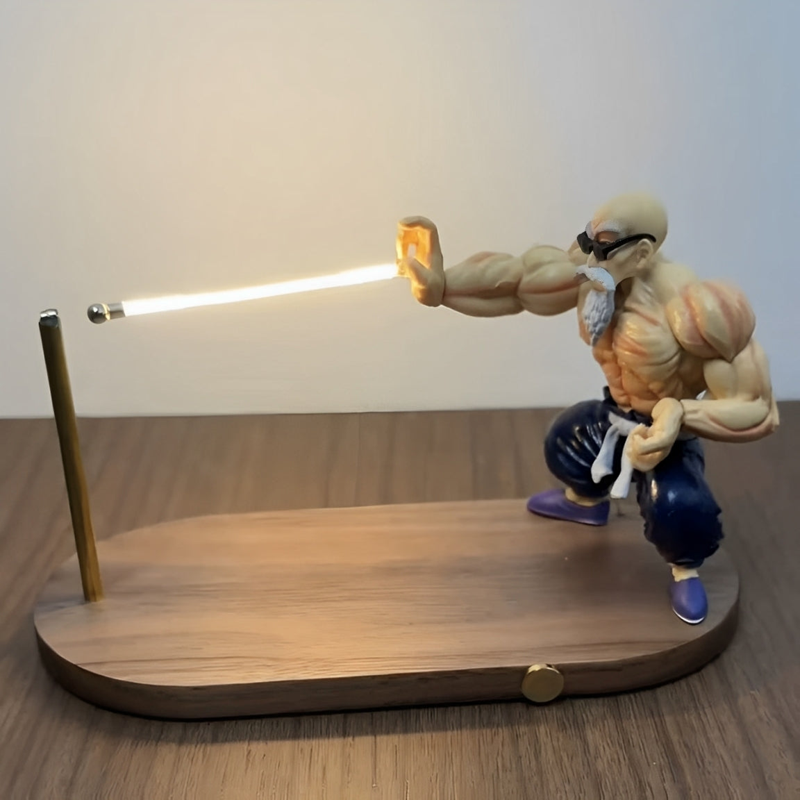 Lampu anime Master Roshi menembak letupan tenaga putih pada permukaan kayu